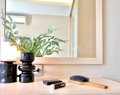 a bathroom counter with a mirror and a brush at 5min Metro | KingBed | Kitchen full | Netflix WiFi in Khlong Toei