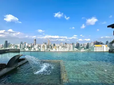 a dolphin in the water with a city in the background at 5min Metro | KingBed | Kitchen full | Netflix WiFi in Khlong Toei