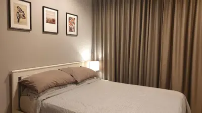 a bedroom with a bed and a window with curtains at The Politan Aqua, River Front in Ban Sai Ma