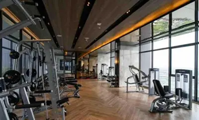 a gym with several treadmills and cardio machines at The Politan Aqua, River Front in Ban Sai Ma
