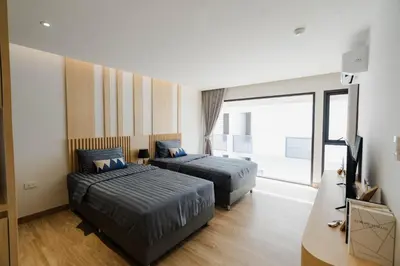 a hotel room with two beds and a television at I-Zen Residence Central Eastville in Bangkok