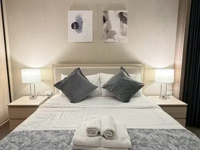 a bedroom with two towels on a bed with two lamps at 2 bed 2 bath luxury appartment Convention Center in Bangkok