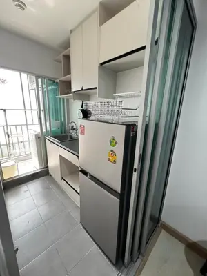 a kitchen with a white refrigerator and a window at คอนโดเดอะคิทท์พลัส 113 in Ban Khlong Samrong