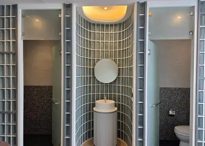 a bathroom with a toilet and a mirror on a wall at Warm Pillow Hotel Bangkok in Bangkok