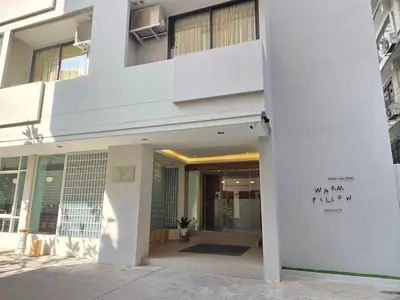 a white building with writing on the side of it at Warm Pillow Hotel Bangkok in Bangkok