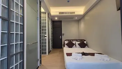 two beds in a room with a hallway at Warm Pillow Hotel Bangkok in Bangkok