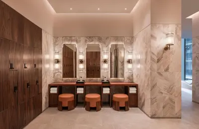 a bathroom with a vanity with stools and mirrors at Andaz One Bangkok in Bangkok