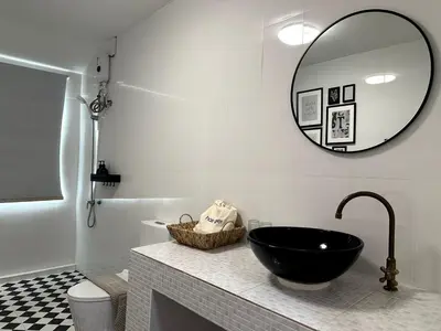 a bathroom with a black sink and a mirror at Delightful Townhouse in the Heart of Sukhumvit in Bangkok