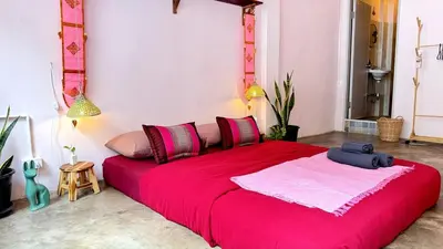a bedroom with a large red bed in a room at Baan YentaFo - Pink House in Talad Noi in Chinatown