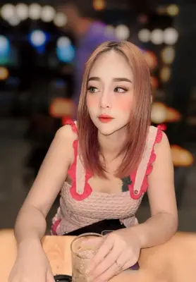 a woman sitting at a table with a glass at Noey sun in Sathani Sam Sen