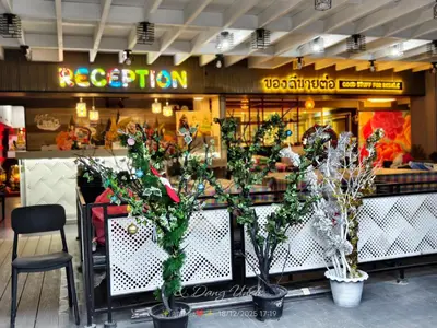 a restaurant with potted trees in front of a counter at โรงแรม เลิฟ บีเคเค in Amphoe Phra Khanong