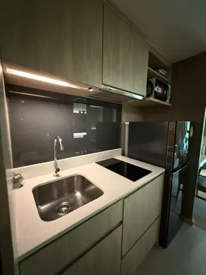 a kitchen with a sink and a black refrigerator at Cozy room in Sukumvit in Bangkok