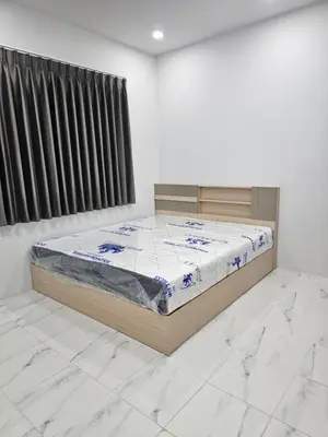 a bedroom with a bed in a white room at Cozy Corner in Samut Prakan