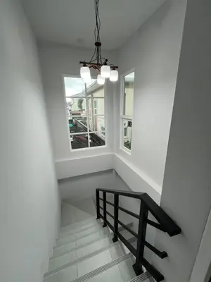 a stairway with a bench and a window at Cozy Corner in Samut Prakan