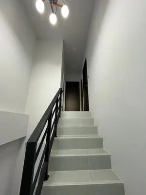 a hallway with stairs and a ceiling fan at Cozy Corner in Samut Prakan