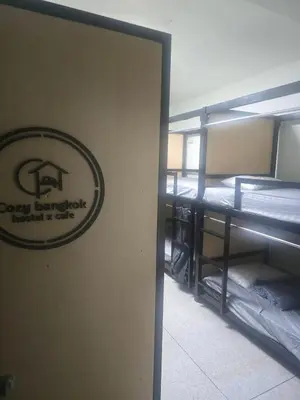a room with bunk beds and a sign on the wall at Cozy bangkok hostel in Bangkok