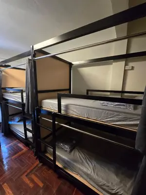 two bunk beds in a room with wooden floors at Cozy bangkok hostel in Bangkok