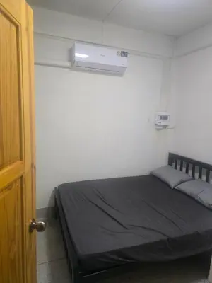 a small bedroom with a bed with a window at Cozy bangkok hostel in Bangkok