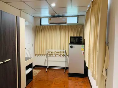 a room with a refrigerator and a table in it at Palmhouse studio room in Bang Khen