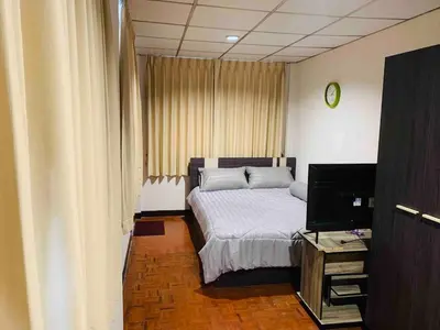 a bedroom with a bed and a tv in it at Palmhouse studio room in Bang Khen