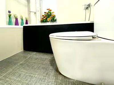 a white toilet in a bathroom with flowers at AkkHouse in Ban Bang Toei (1)