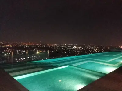 a swimming pool at night with a view of a city at ห้องพัก แบบ Studio ติดเซ็นทรัลเวสเกต in Ban Bang Krabu