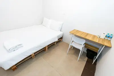 a small bedroom with a bed and a desk at XX The Hidden Khaosan Road Bangkok in Bang Bua Thong Railway Station