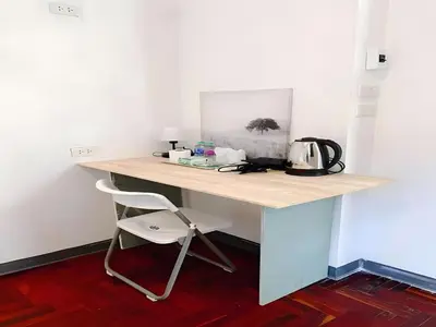 a desk in a room with a table and a chair at XX GO INN Silom - BTS Surasak in Yan Nawa