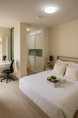 a bedroom with a large white bed and a desk at Executive 1 BR and Sofa bed Next to T21 Asoke BTS in Bangkok