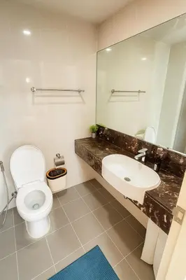 a bathroom with a toilet and a sink and a mirror at Executive 1 BR and Sofa bed Next to T21 Asoke BTS in Bangkok