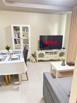 a living room with a table and a television at Executive 1 BR and Sofa bed Next to T21 Asoke BTS in Bangkok