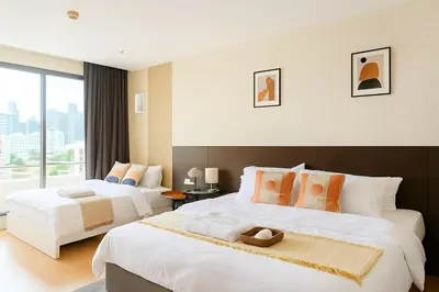 a hotel room with two beds and a large window at Modern 2 Bed Executive Unit 5min to Nana BTS in Bangkok
