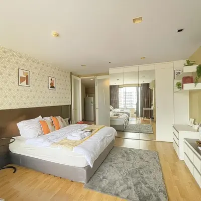 a bedroom with a large white bed with orange pillows at Modern 2 Bed Executive Unit 5min to Nana BTS in Bangkok