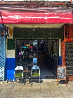 a restaurant with two chairs and a table in the window at Happy Hope Khao San in Bangkok