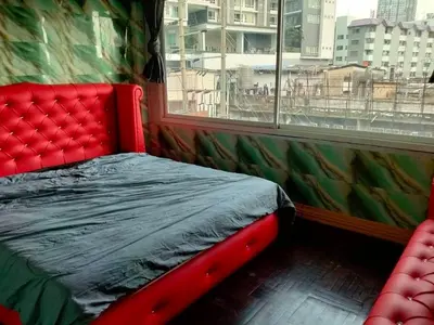 a red bed in a room with a window at A fantastic house next to W district food market in Amphoe Phra Khanong