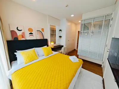 a bedroom with a yellow bed and a window at Downtown, Cozy 1BR, 48sqm, Middle of ThongLo, High Floor, Pool, Gym, Fast Wifi in Bangkok