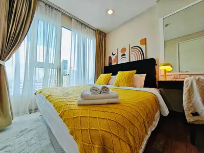 a bedroom with a yellow bed with towels on it at Downtown, Cozy 1BR, 48sqm, Middle of ThongLo, High Floor, Pool, Gym, Fast Wifi in Bangkok