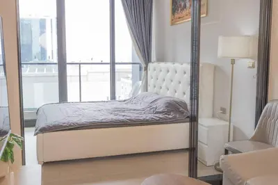 a bedroom with a bed and a mirror at KINGbed with Pool Gym and Standing Desk near MRT in Bangkok