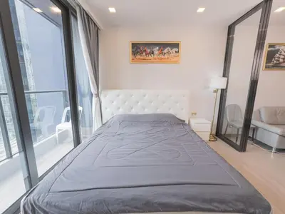 a large bed in a room with a large window at KINGbed with Pool Gym and Standing Desk near MRT in Bangkok