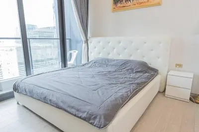 a white bed in a room with a large window at KINGbed with Pool Gym and Standing Desk near MRT in Bangkok