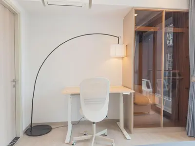 a desk with a white chair and a lamp at KINGbed with Pool Gym and Standing Desk near MRT in Bangkok