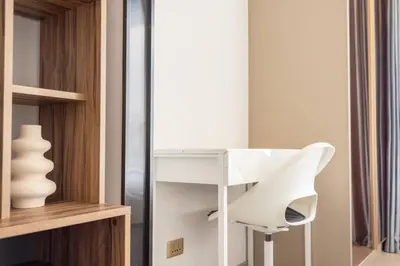 a white chair in a room with a mirror at 49floor with Workspace Pool and Gym with MRT 200m in Bangkok