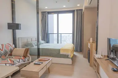 a bedroom with a bed and a couch and a tv at 47fl Skyview with Balcony Pool Gym 200m from MRT in Bangkok