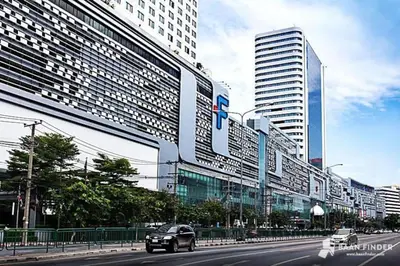 a car driving down a city street with tall buildings at 47fl Skyview with Balcony Pool Gym 200m from MRT in Bangkok