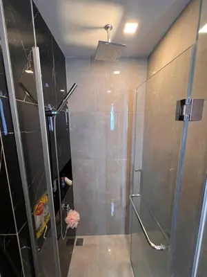 a bathroom with a shower with a glass door at In Unit Workspace Gym and Infinity Pool MRT 200m in Bangkok