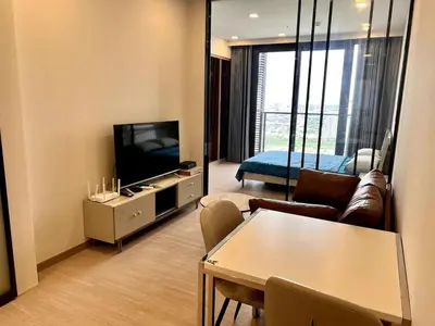 a living room with a couch and a tv and a table at High Floor Apt with Large Living Room Pool and Gym in Ban Na Song