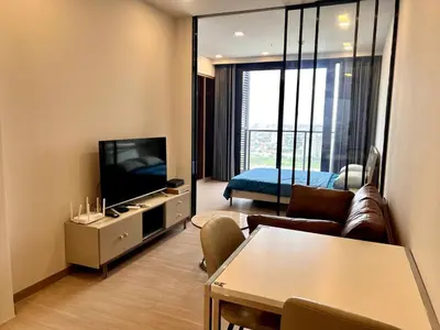 a living room with a couch and a television at High Floor Apt with Large Living Room Pool and Gym in Ban Na Song