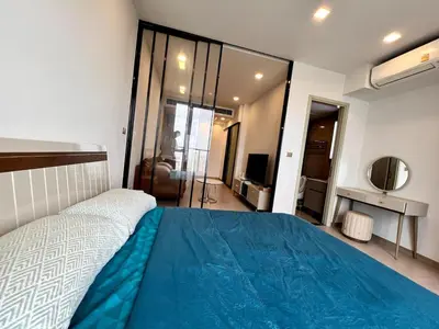 a bedroom with a bed with a blue blanket on it at High Floor Apt with Large Living Room Pool and Gym in Ban Na Song