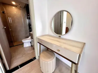 a bathroom with a vanity with a mirror and a toilet at High Floor Apt with Large Living Room Pool and Gym in Ban Na Song