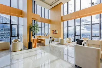 a lobby with chairs and tables in a building with windows at High Floor Apt with Large Living Room Pool and Gym in Ban Na Song